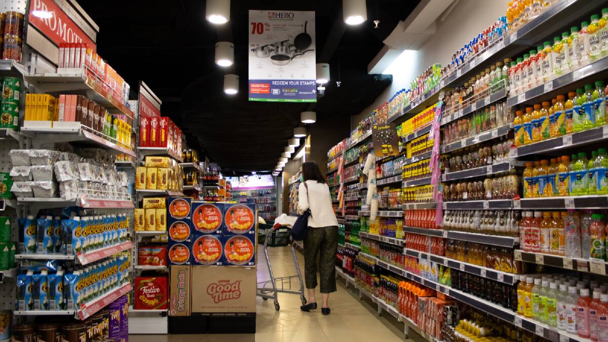 Woman shops at a supermarket. Picture via Canva