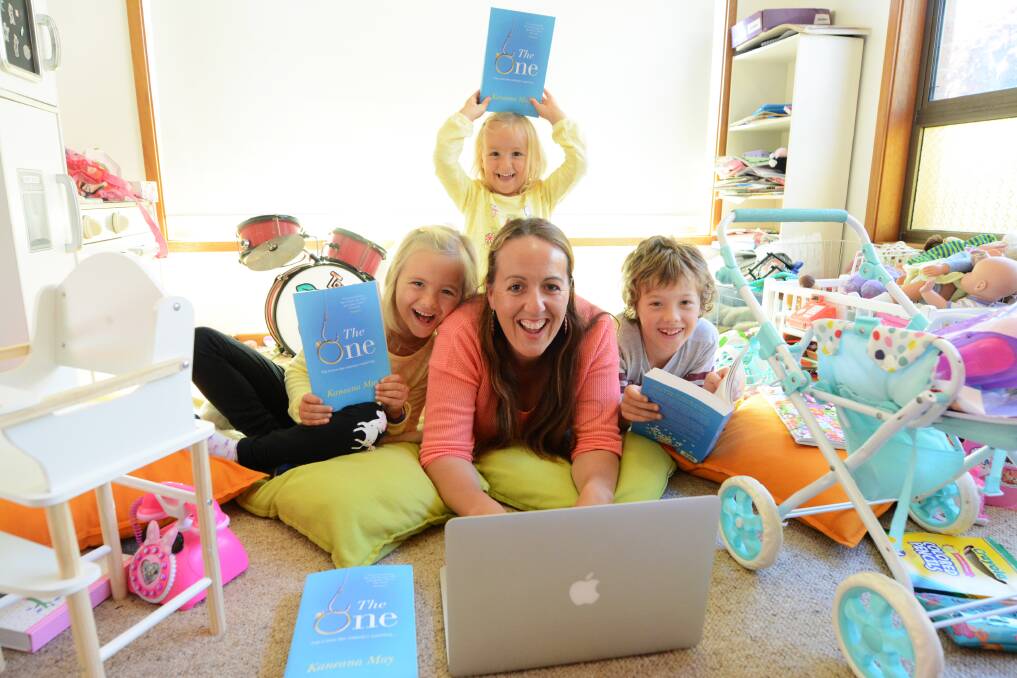 Work and play: Kaneana May worked around the life of her family to realise her dream of becoming a published author. Kaneana is pictured with her children, Minnie, Cherry and Leo, all proudly holding copies of their mum's new book, The One. Photo: Scott Calvin