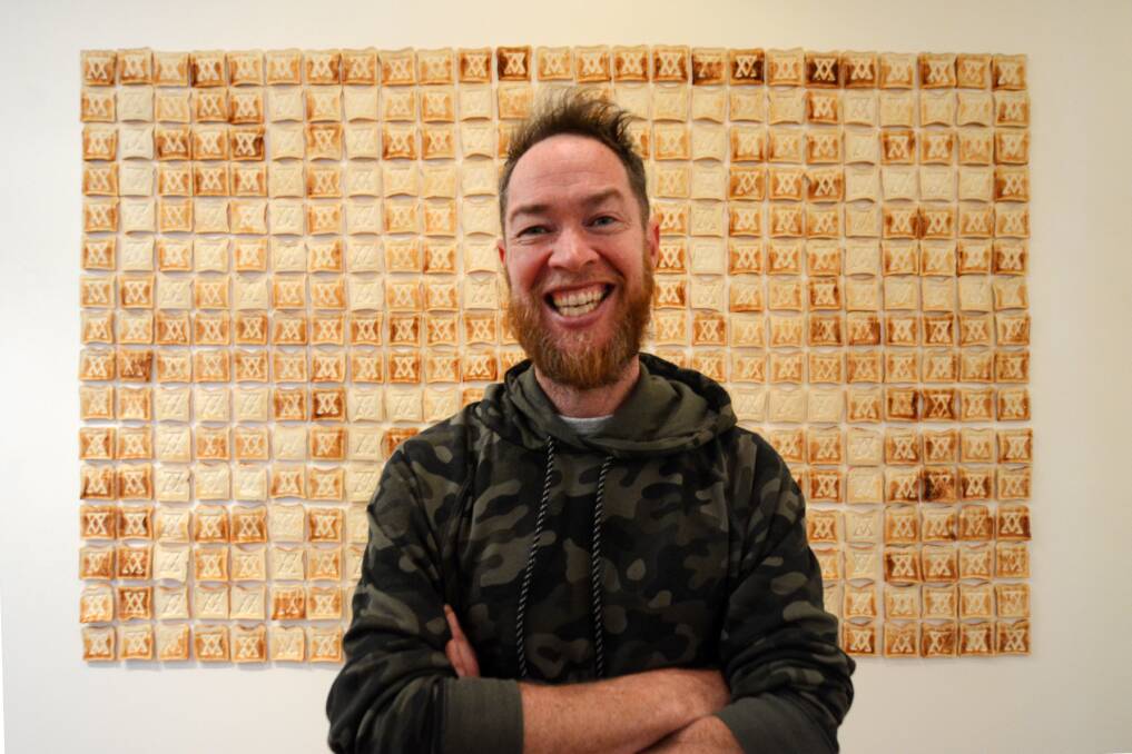 Excited to exhibit in Taree: Jason Wing in front of his toast installation, part of the What Binds Us exhibition at the Manning Regional Art Gallery.