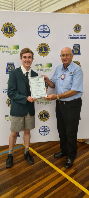 Patrick Guthridge receives his certificate from George Begg from the Manning River Lions Club.