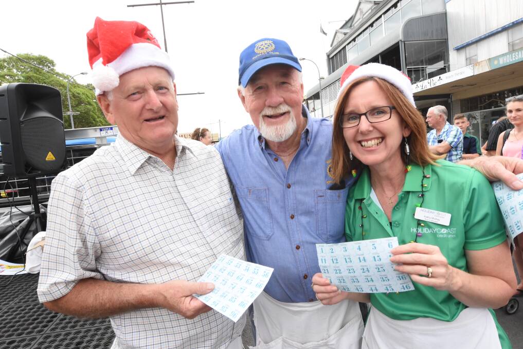 Participate in the Chocolate Wheel: Colin Butcher, Ron Hindmarsh and Kathy McKay at the 2018 Wingham Christmas Street Carnival, which is on again this Thursday.