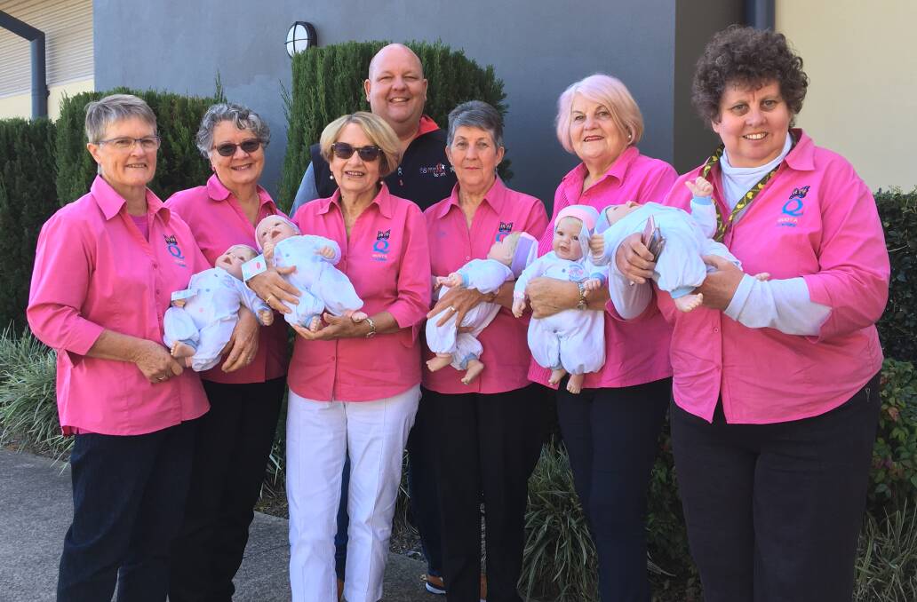 Therapy dolls make a difference: Nursing the dolls are Taree Quota Club members Marj Phillips, Trish Webber, Nancy Boyling, Dawn Beer, Lyn Jones and Romany Low, with Club Taree's Paul Allan.