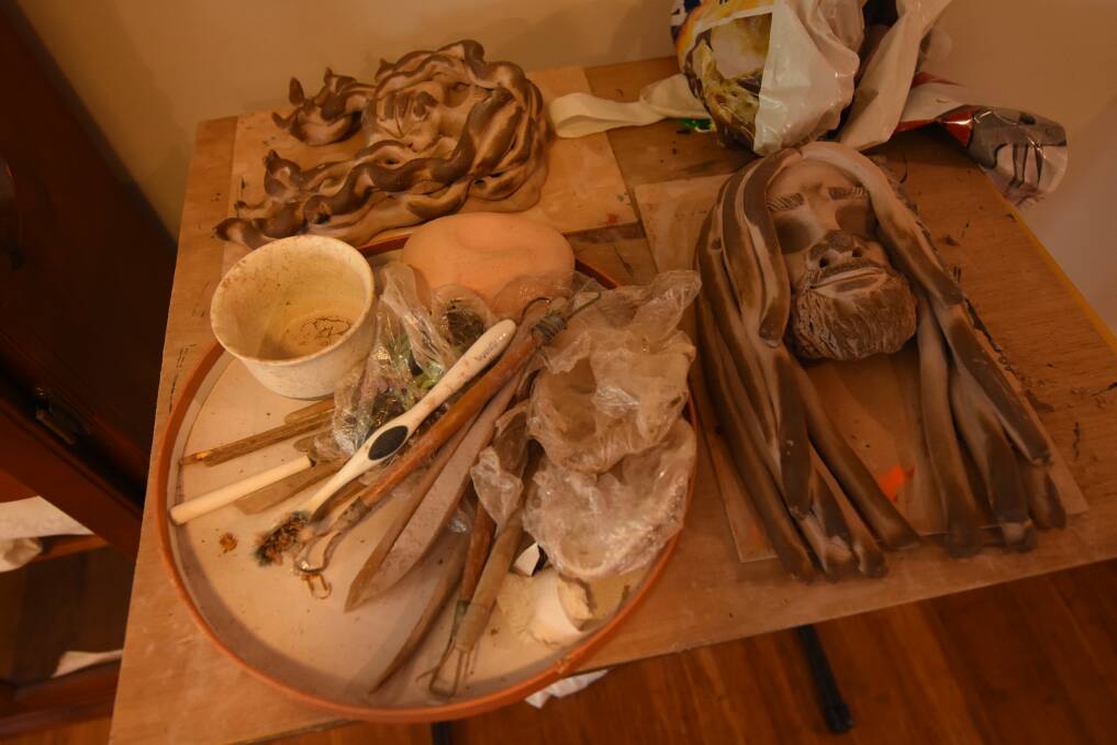 Raechel Saunders started learning clay work from a young age, by watching her father Russell work. Pictured are some of her clay faces and tools that she uses. Photo: Scott Calvin.