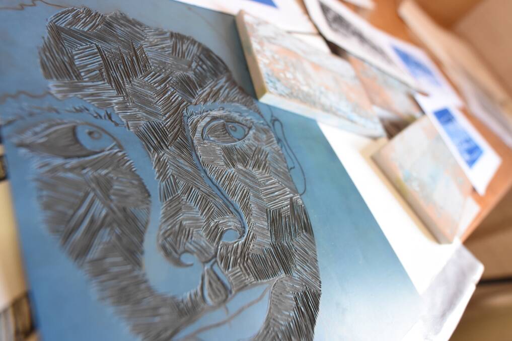 Lino print: Ali has carved a face into the linoleum. She will cover it in colour to then print the relief surface. 