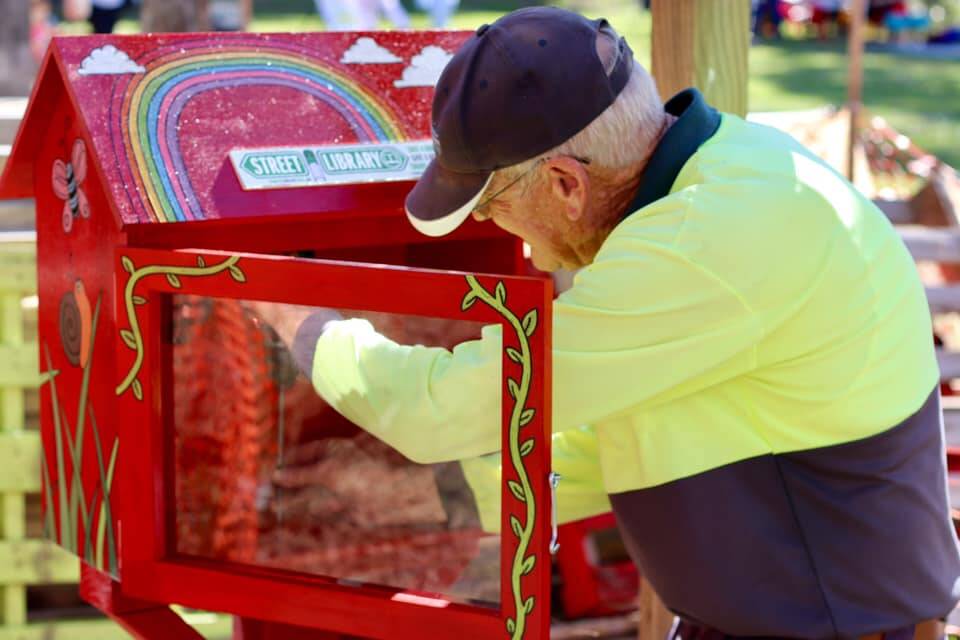 Bill Dennis installs the street library at the Taree Community Garden. Photo: Supplied.