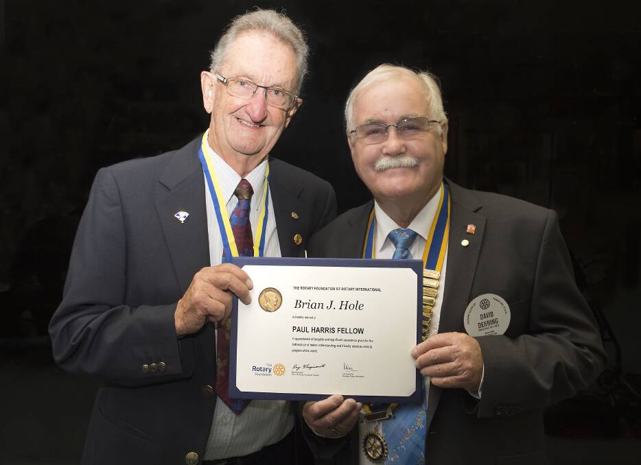 Honour: Brian Hole receives his Paul Harris Fellow certificate from Rotary Club of Taree president David Denning. Photo: Ashley Cleaver/Cleavers Images.