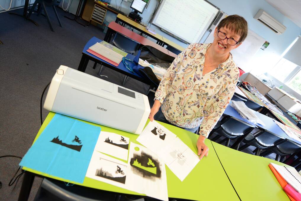 Teacher Barbara Tate with the scan and cut machine, which uses Abobe software.