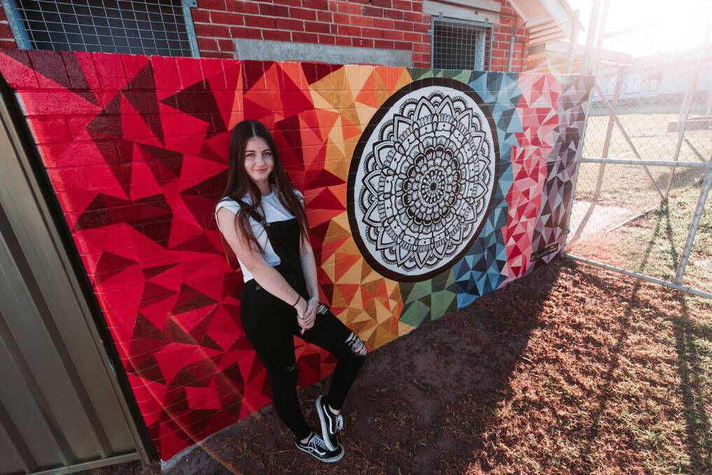 Chloe Hargreaves with her finished mural. Photo: Jake Davey.