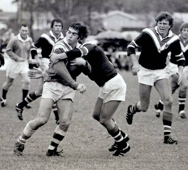 Mark Hogan is stopped by an Eastern Suburbs player during United's trial against the Roosters in 1975. The great Ron Coote (right) is coming across in cover.