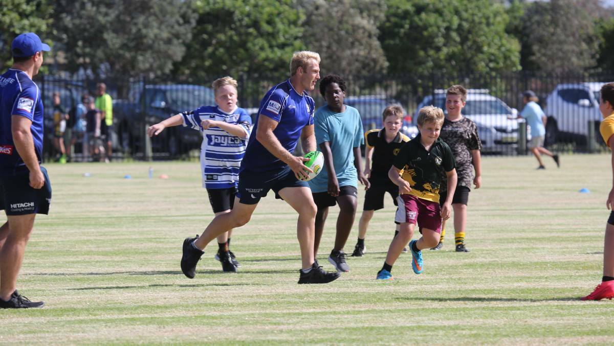 Canterbury star Aiden Tolman enjoying a game of touch football with some juniors at Tuncurry earlier this week. This was part of a promotional visit before Saturday's trial game against Canberra. Photo Steve Turner.