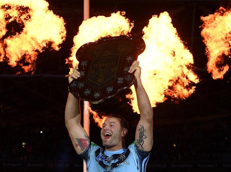 A jubilant Boyd Cordner holds the State of Origin shield aloft after the win in game three this year. Photo AAP.