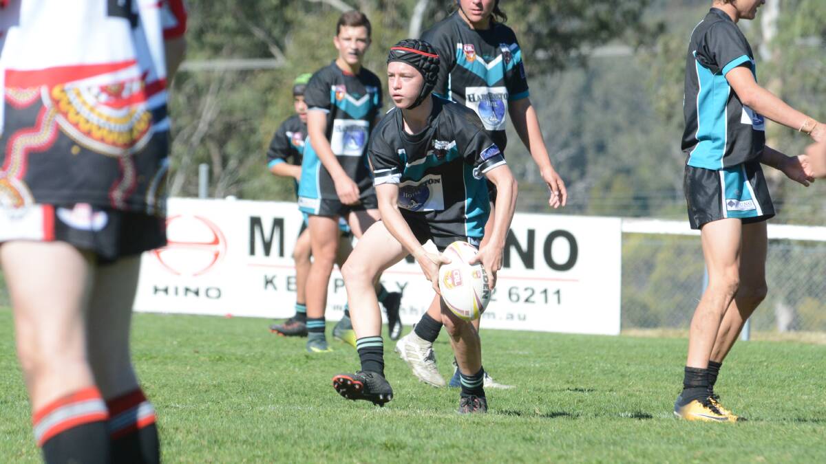 Ryan Young prepares to offload for Taree during the under 15 grand final against Red Rovers played at Wingham.