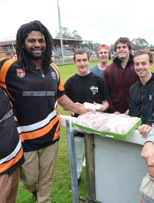 Former NRL star Jamal Idris helps members of Wingham's under 18 team with a raffle at the Wingham Sporting Complex. He didn't play but was a big hit.