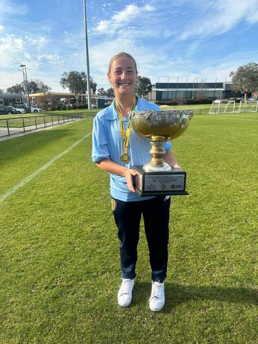 Saffron Grass with the winner's trophy after NSW's dominating performance in the Australian All Schools Football Championship played in Canberra.