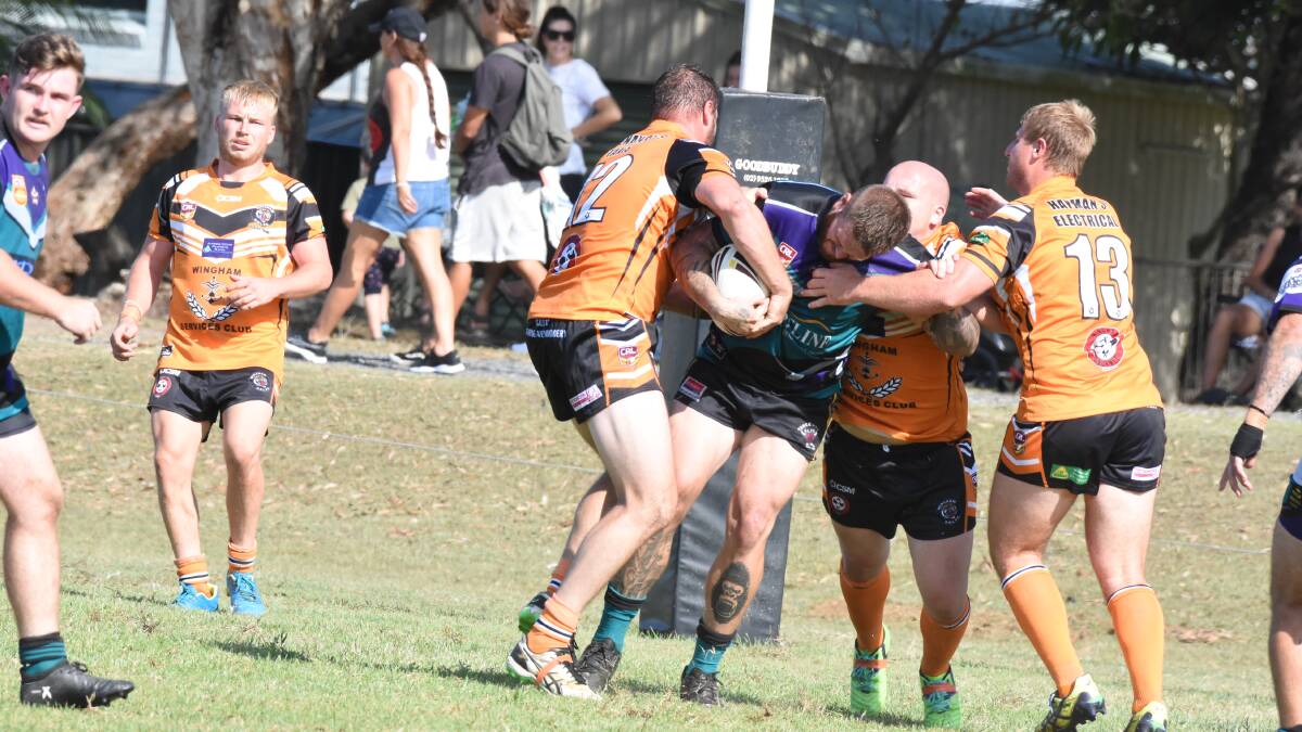 Wingham Tigers defenders wrap up a Taree City ball carrier during the opening round of the pre-season competition at Old Bar. The Tigers and Old Bar meet in the pre-season final on Saturday at Tuncurry. 