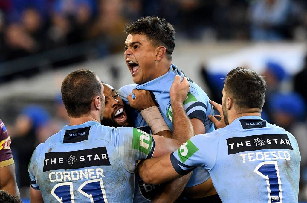 Blue beauty: Latrell Mitchell celebrates after scoring for NSW in the opening State of Origin match. NSW captain Boyd Cordner is among those congratulating him. Photo AAP.