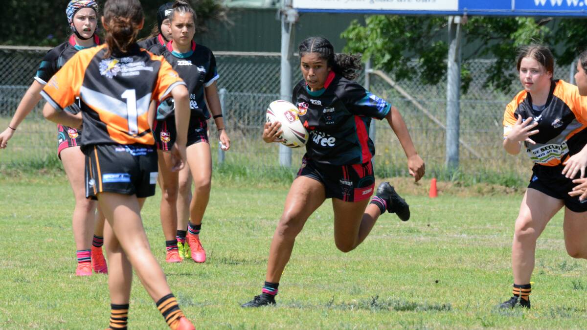 Asha Lawton on the run for Taree under 15s in the North Coast 11-a-side women's rugby league clash against Wingham at Taree this month. 