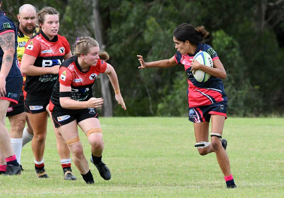 Kiralee Ridgeway from Manning Ratz attempts to fend off a Gloucester opponent during the women's 10s clash at Taree Rugby Park last month.