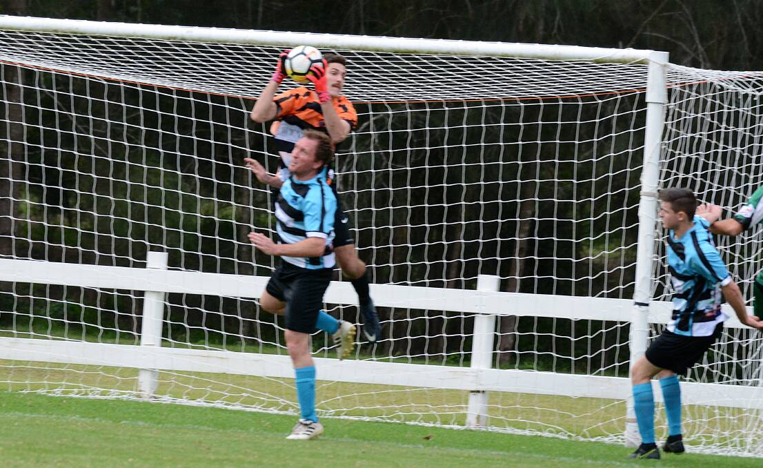 Taree goalkeeper Curtis Jones goes above team-mate Justin Atkins to make a save in the clash against Port United. The Wildcats hope Jones is fit for Saturday's clash against Boambee at Boambee.