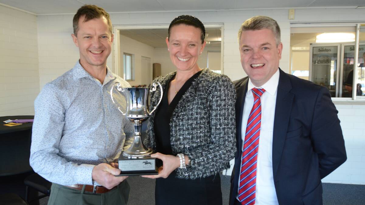 Successful trainer Jason Deamer from Newcastle is presented with the Taree Cup by Katie and Justin Stack representing the sponsors, Stacks Law Firm.