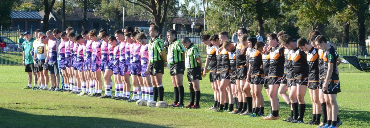Taree City and Wingham players and match officials observe a minute's silence before the start of the Kristylea Bridge Memorial Cup match at the Jack Neal Oval.  
