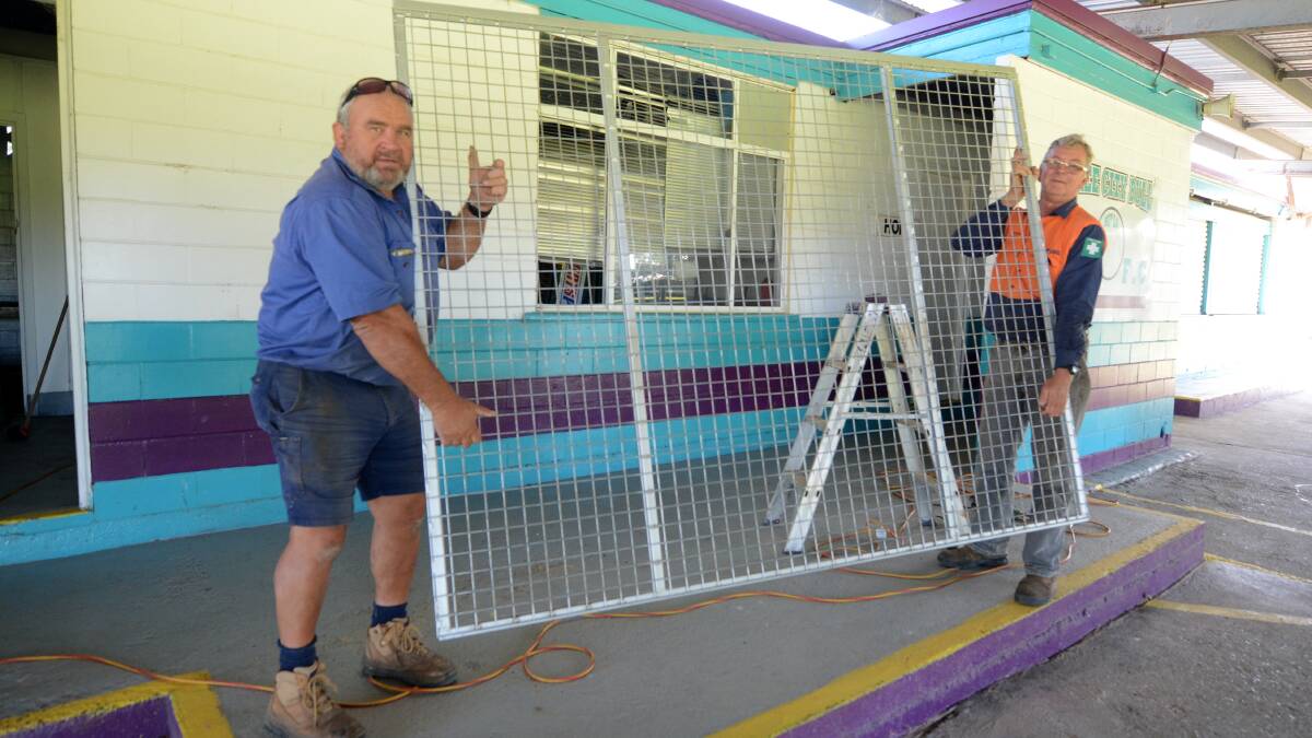 Taree City president Michael Clarke and Darryl Hammond installing the security screens at the Neal Oval earlier this week.
