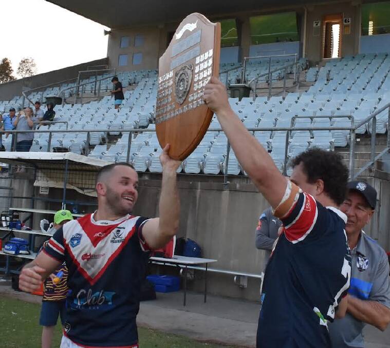 Old Bar co-coaches Mick Henry and Jordan Worboys hold up the Group Three premiership shield after the win over Port Macquarie. Photo Mardi Borg