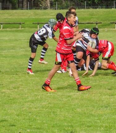 Brody Coble (black headgear) takes the ball forward during a representative junior rugby fixture.
