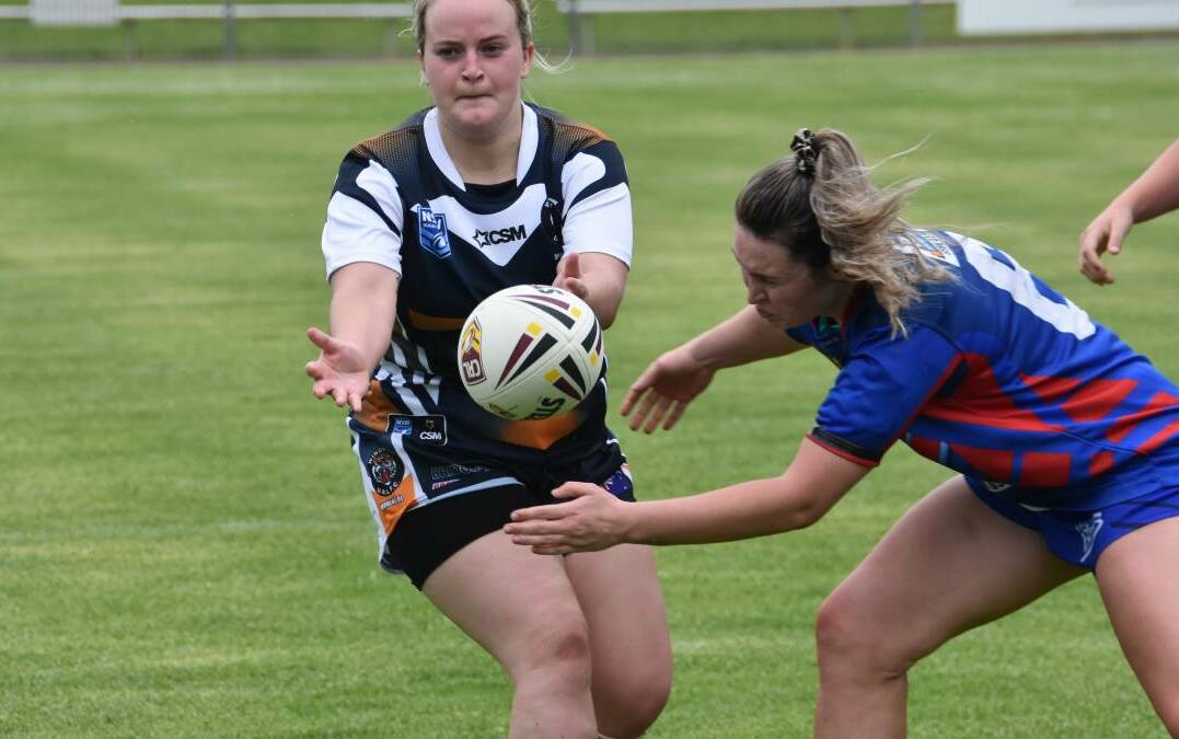 Natalie Watson from Wingham unloads as a Wauchope defending moves in during the opening round clash in the North Coast Women's Rugby League at Port Macquarie. Photo Port News