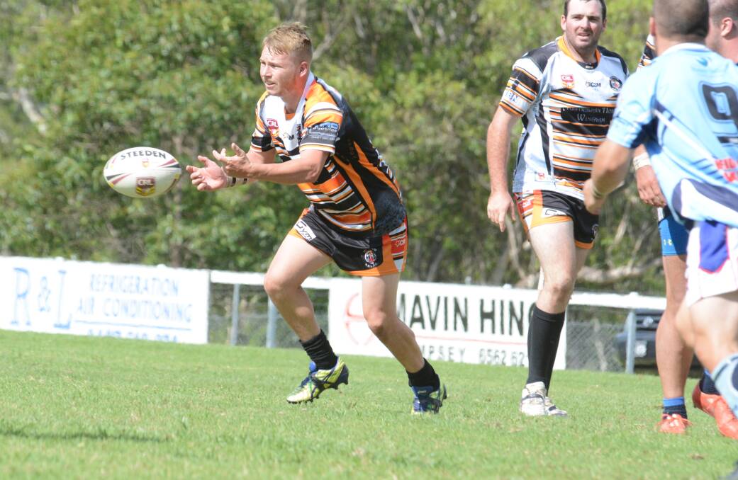 Wingham hooker Mitch Collins off-loads during the club's trial against Shortland played at Wingham earlier this month.