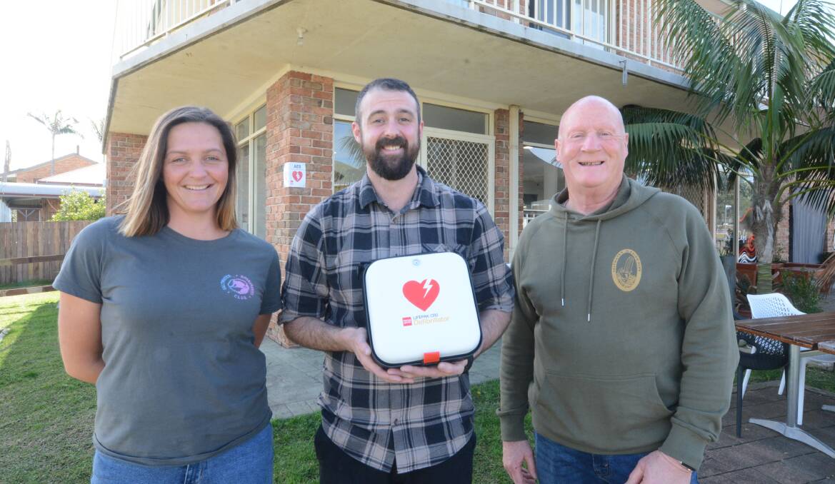 Saltwater Boardriders secretary Kirby Stanley, Mitch Spiteri from Wallabi Point Cafe and Steve Keevers from the Saltwater Malibu Boardriders with the defibrillator to be kept at the cafe for use by the community.