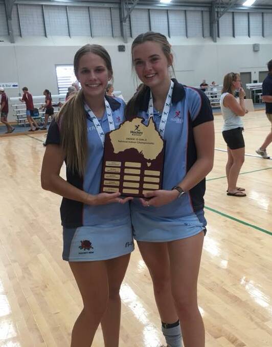 Bree Pensini and Lara Watts with the championship trophy after NSW under 15 girls victory over Queensland in the Australian Indoor Hockey Championship at Goulburn. Photo Trish Page.