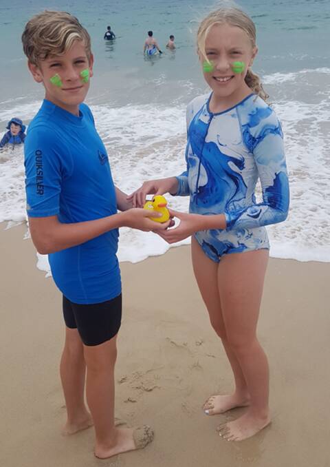 Cousins Noah Munro from Freshwater and Jess Edler from Frenchs Forest, used a baby's bath thermometer to check the water temperature at Forster. Picture Anne Evans.