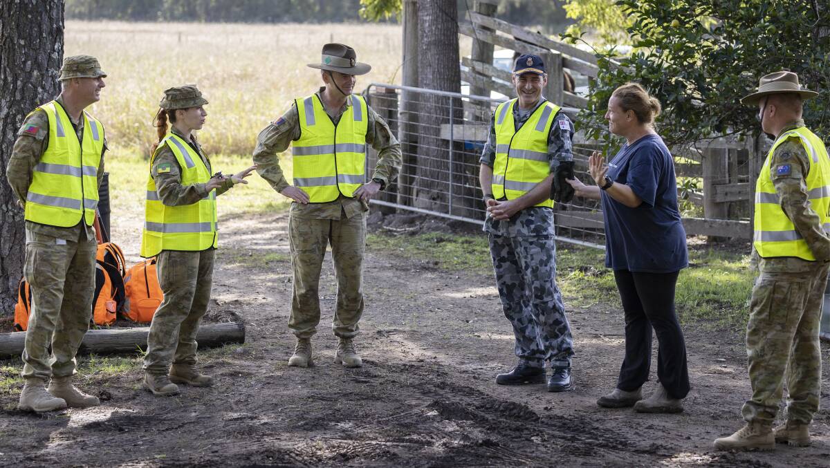 Commander Joint Task Force 629, Rear Admiral Robert Plath, RAN, and Commander Joint Task Group 629.1 Brigadier Mick Garraway talk with Australian Army personnel and a Taree resident. Photo: CPL Sagi Biderman.