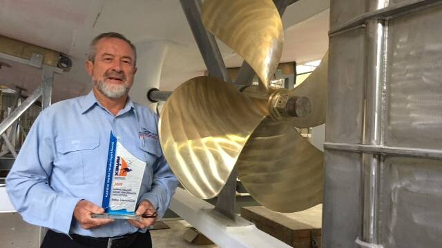 Alan Steber, latest AIMEX trophy in hand, is dwarfed by the prop of the 60ft fisheries
research vessel under construction for the government of Mauritius. 