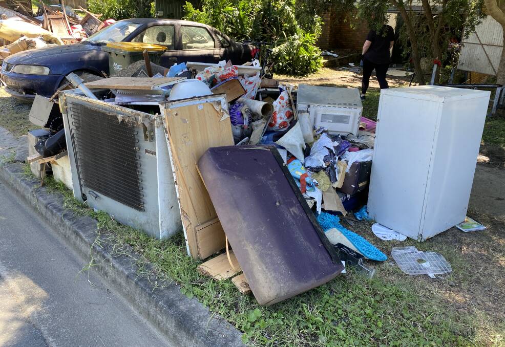 Flood waste piled kerbside at Wingham to be collected by the clean-up strike teams.