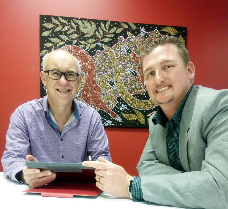 Manager of MidCoast Council Libraries, Chris Jones, discusses the new tech support program with Optus general manager for the Mid North Coast, Chris Simon.