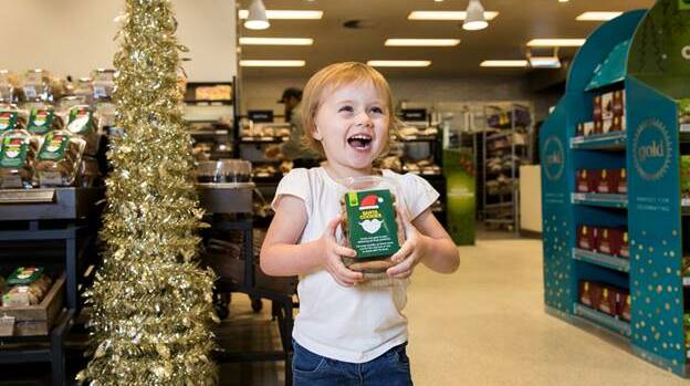 Dakota Morgan with Woolworths Dreamy Chocolate Santa Cookies supporting the Woolworths OzHarvest Christmas Appeal.
