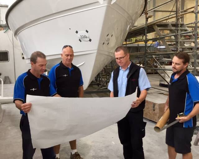 Project manager Colin Steber, supply chain controller Finn Stricker, development engineer/research officer Steve Hunt and production controller Mark Facer review the general arrangement of the Steber 40 under construction at the company's Taree factory.