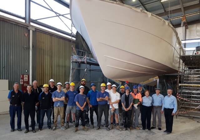Steber International staff are dwarfed by the huge fibreglass hull after its release from the mould. 