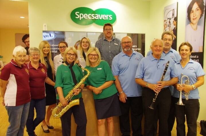 Helen Bell (with saxophone) with Specsavers Taree staff, Taree Lions and Club Taree Community Concert Band members.