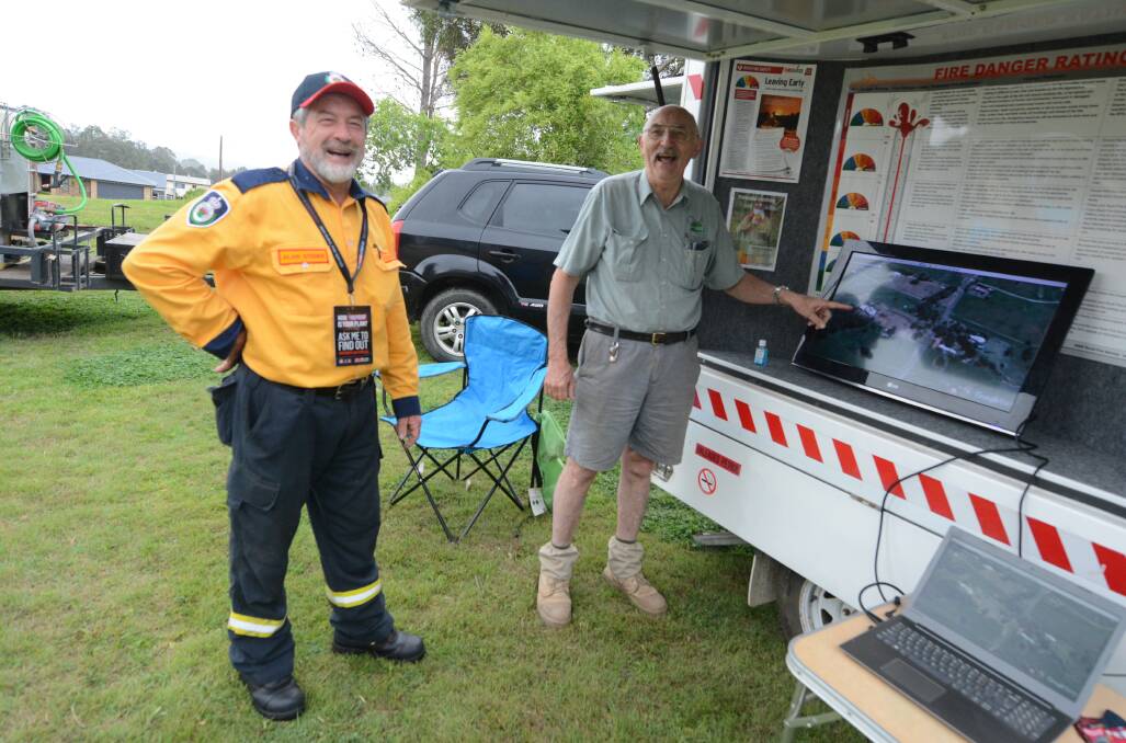 Tinonee RFS Brigade president Alan Steber and resident Peter Calabria, viewing the GPS mapping showing last season's fire damage.