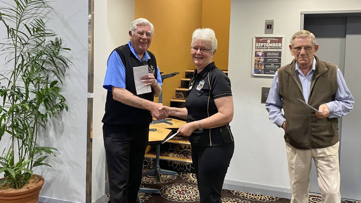 Wingham Services Club president, Harry Rider presenting Wingham RSL Sub-branch secretary Leonie Gilford with donation, watched by John Rooimans, representing Legacy which also received a donation from the services club.