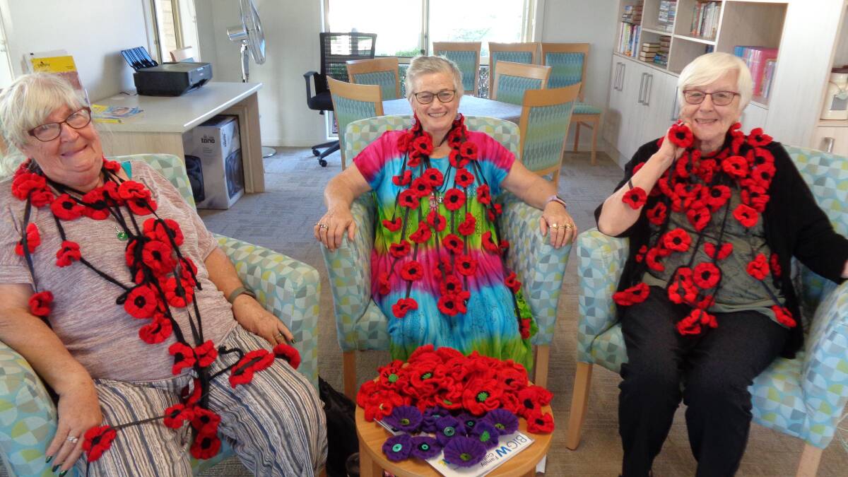 Anne Sinclair, Pat Welna and Pam Smith with some of the red poppies the Ingenia Gardens knitting group has prepared.