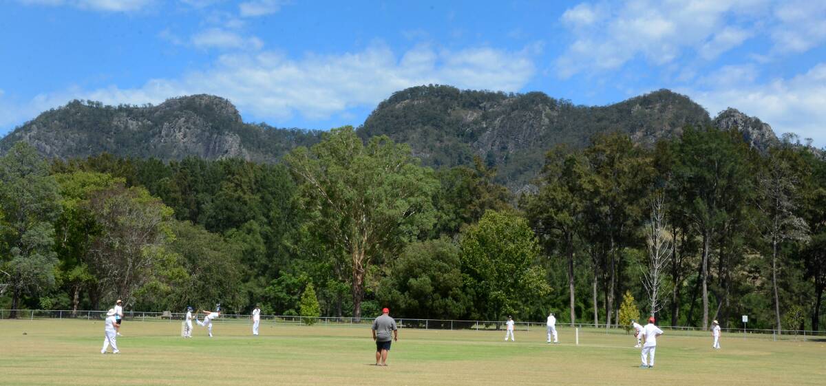 Residents play cricket in Gloucester District Park with the stunning backdrop of the Buccan Buccan (Bucketts range)