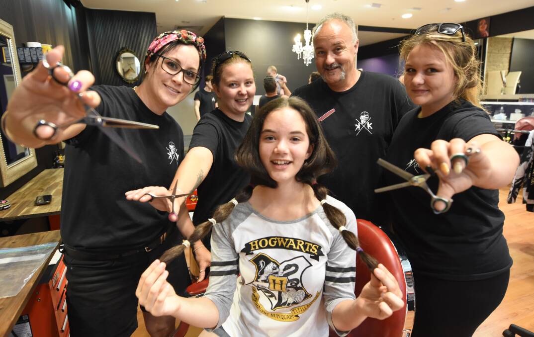 Amber Hunter, Stephanie Collins, Mick Collins and Sharntel Collins get ready to snip off Daisie Anderson's ponytails. Photo Scott Calvin.