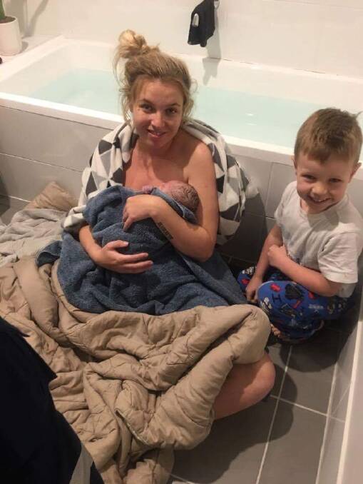 Baby and the bathwater: Mother Keilee and four-year-old son Kruz huddle on the floor of their bathroom where baby Airlie was born minutes earlier. 