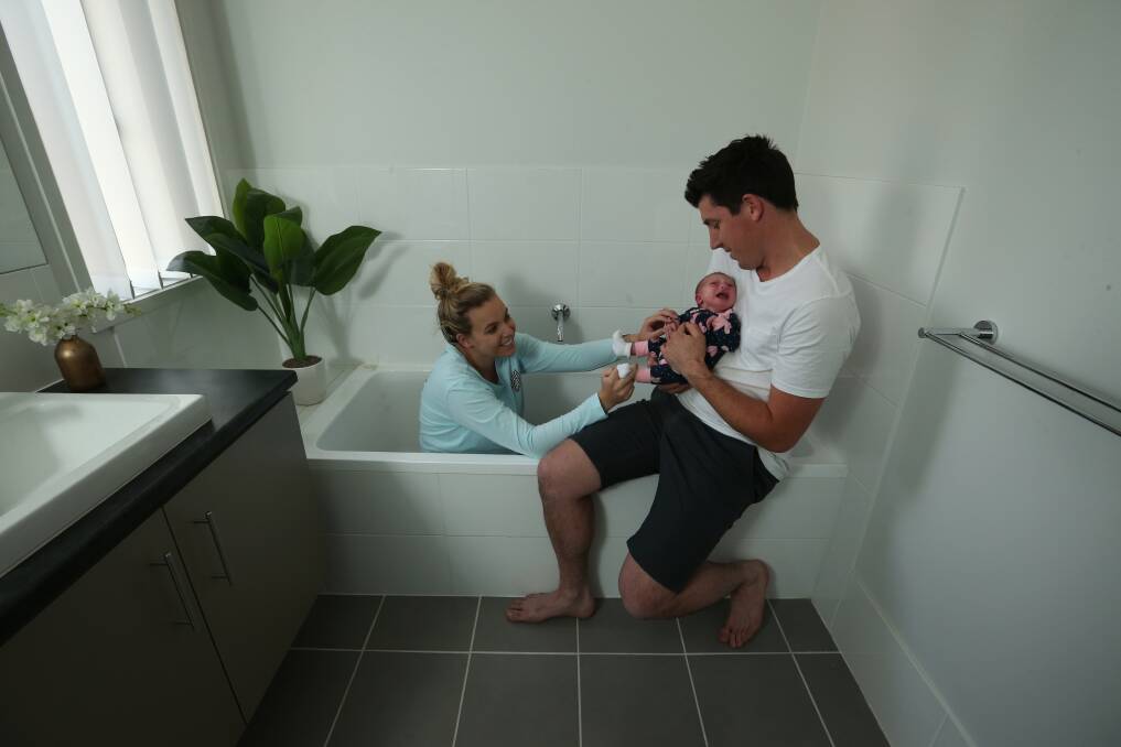 Scene of the birth: Keilee, Airlie and Brett Keegan at Airlie's birthplace, which doubles as their bathroom. Picture: Simone De Peak. 