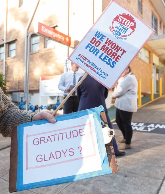 Nursing staff at Kurri Kurri Hospital held a small rally outside the hospital to protest a pay freeze by Government. Cessnock MP Clayton Barr was in attendence. Pic shows placards in the hands of a protester. Thursday, May 28, 2020. Picture Max Mason-Hubers MMH / Newcastle Herald / ACM