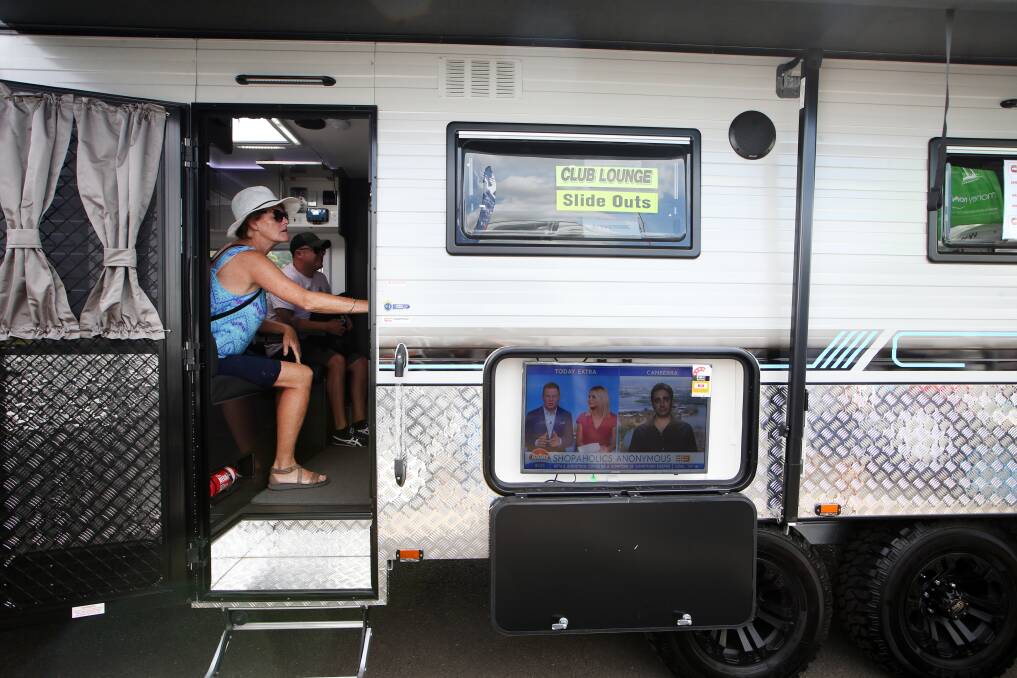 Susanne Stjepanovic inside a $115,000 caravan (with three televisions - one on the outside) at the annual Illawarra Caravan Camping 4WD and Fish Show. Pictures: Sylvia Liber